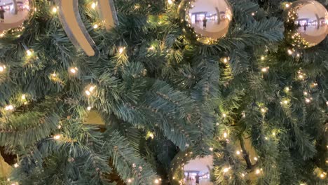 El-árbol-De-Navidad-Iluminado-Con-Luces-Blancas-Sobre-Un-Fondo-Negro-En-Un-Centro-Comercial-Ubicado-En-Cascais-Refleja-Al-Hombre