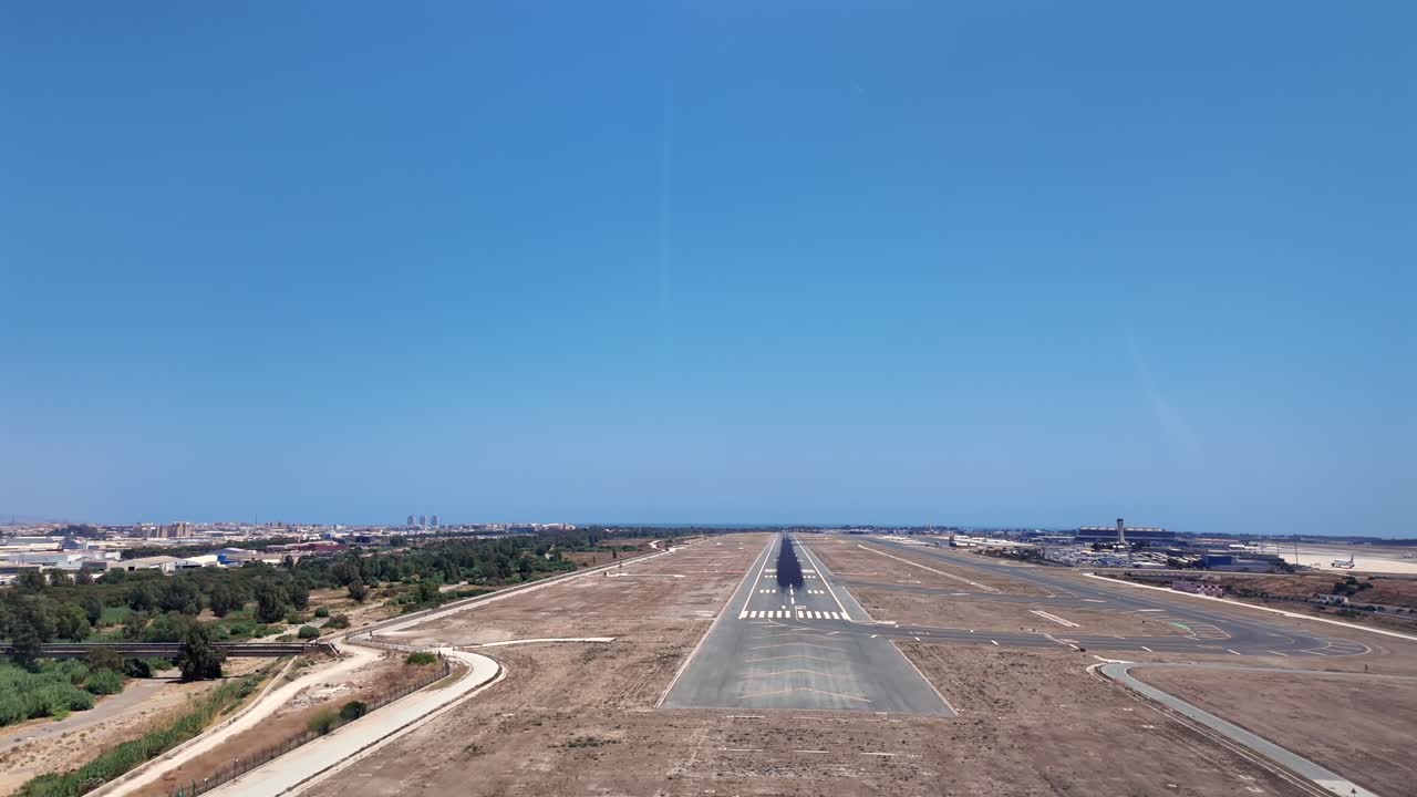 An immersive cockpit view in the final approach to Málaga’s airport runway, with the Mediterranean Sea at the back, under a bright and splendid blue sky