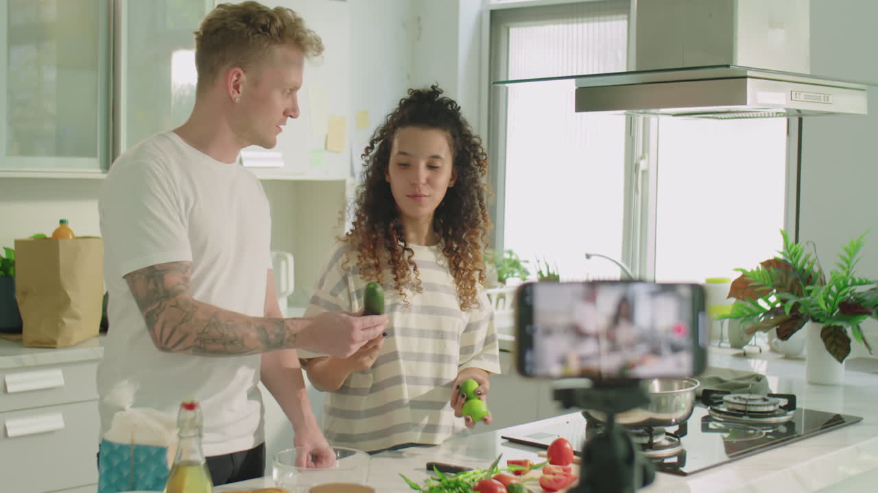 Young Couple Filming Cooking Vlog Together in Kitchen