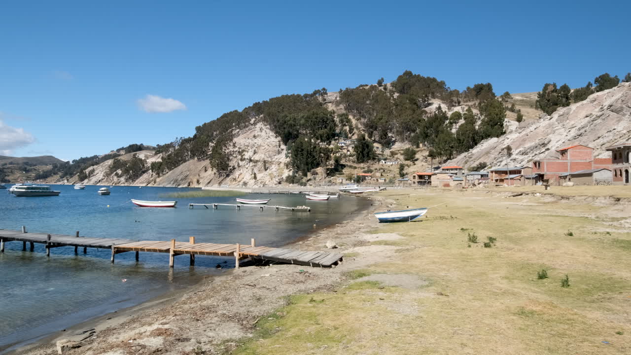 Discover the serene North Port of Challapampa community on Isla del Sol, Bolivia. This video captures the tranquil shores of Lake Titicaca, with local boats by the dock