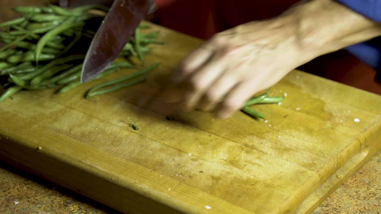 Cutting green beans on a cutting board