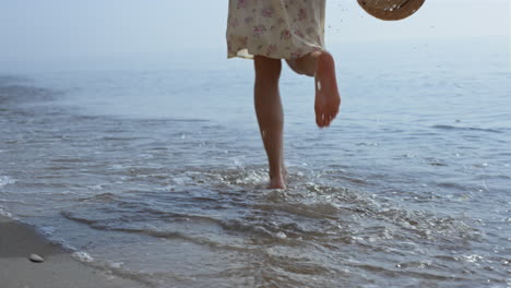 bare woman legs jumping on sea waves close up. girl feet splashing in water.