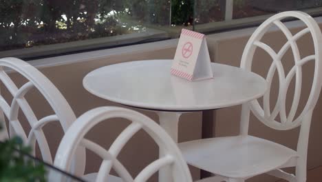 empty outdoor cafe table with no smoking sign