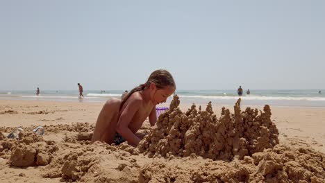 Praia-Da-Rocha-Baixinha,-Portugal---Una-Joven-Está-Construyendo-Castillos-De-Arena-En-La-Playa---De-Cerca