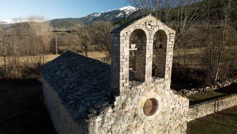 Niedliche-Verlassene-Kirche-Mitten-In-Den-Feldern-Und-Atemberaubende-Ausblicke-Auf-Die-Schneebedeckten-Berge-Am-Horizont