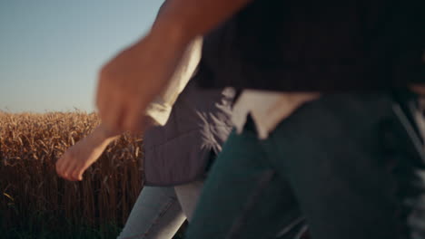 Agronomists-team-walking-field-together.-Hands-going-holding-tablet-closeup.