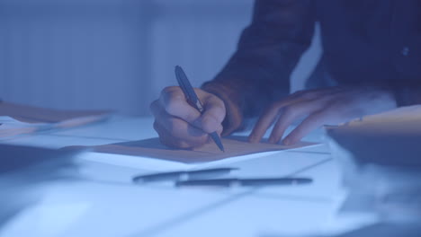 person writing on paper at night