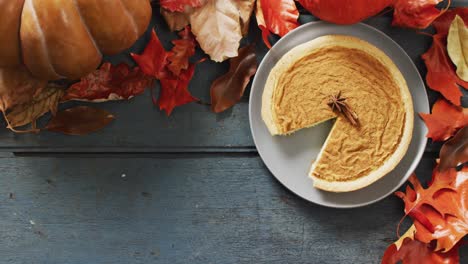 video of autumn leaves, pumpkin, spices and pie on wooden background