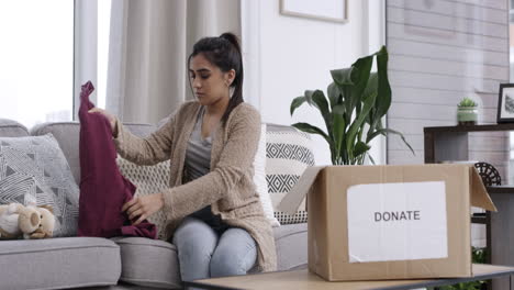 a woman packing items in a donation box at home