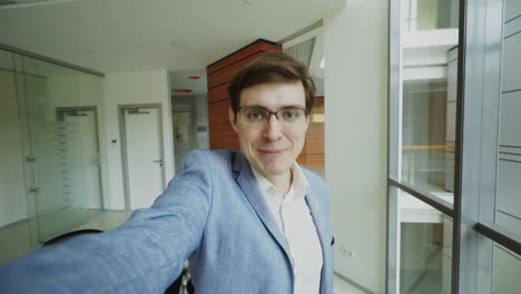 businessman taking a selfie in an office building