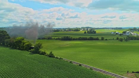 una vista de drones pasando a través del humo y viendo tierras de cultivo amish en una soleada mañana de verano