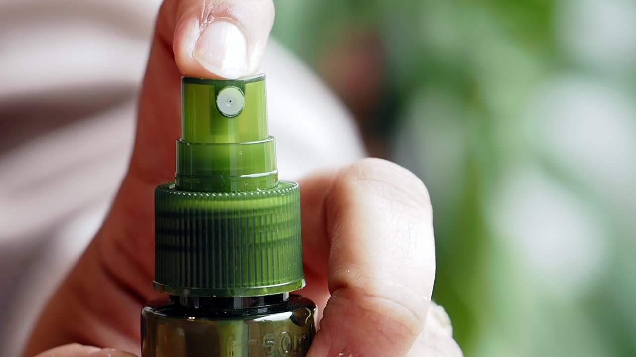 Person Using a Green Spray Bottle
