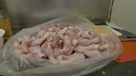 una bolsa llena de muslos de pollo frescos listos para condimentar