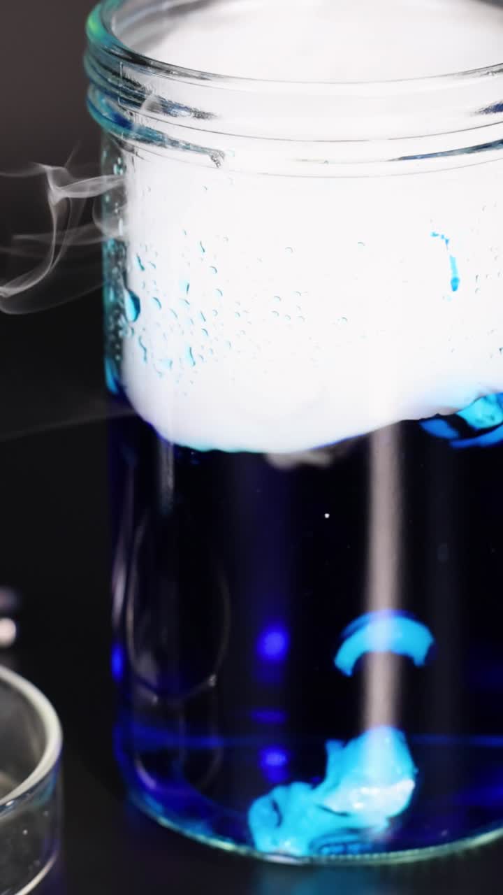 el hielo seco reacciona en el vaso líquido azul