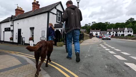 hombre paseando al perro por la calle en llangollen