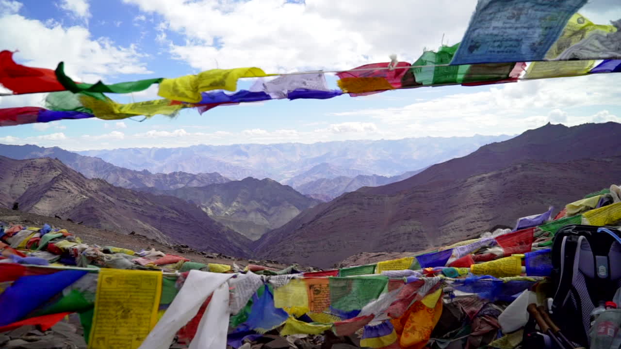 Viewpoint in the Himalayan mountains with Tibetan prayer flags in the wind, push in a handheld shot towards the scenery