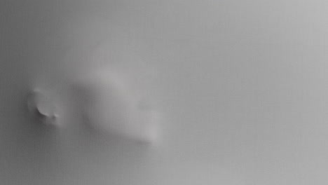 a creepy silhouette of a woman's face appears screaming from the white surface