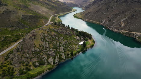 motorboat enters cromwell gorge on clutha river, new zealand, aerial view