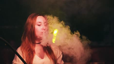 woman smoking hookah in night club