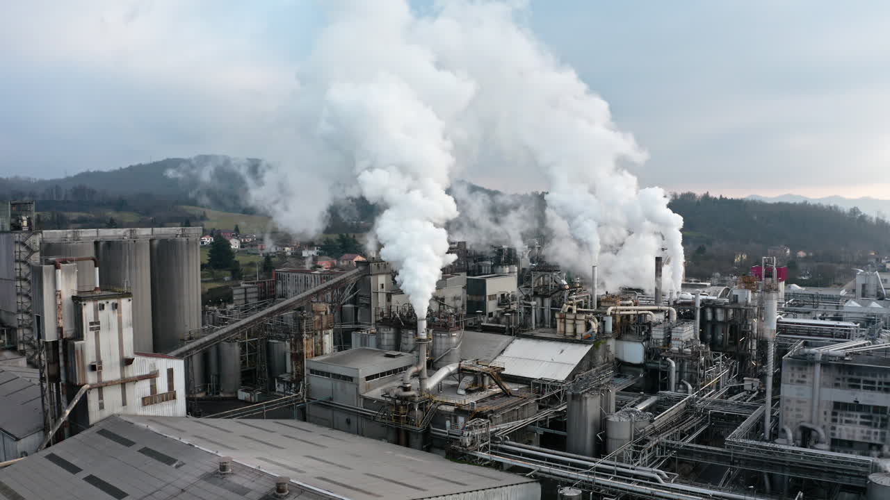Industrial factory emitting thick white smoke, symbolizing pollution and heavy industry