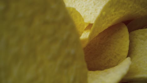 macro video of potato chips falling into a bowl