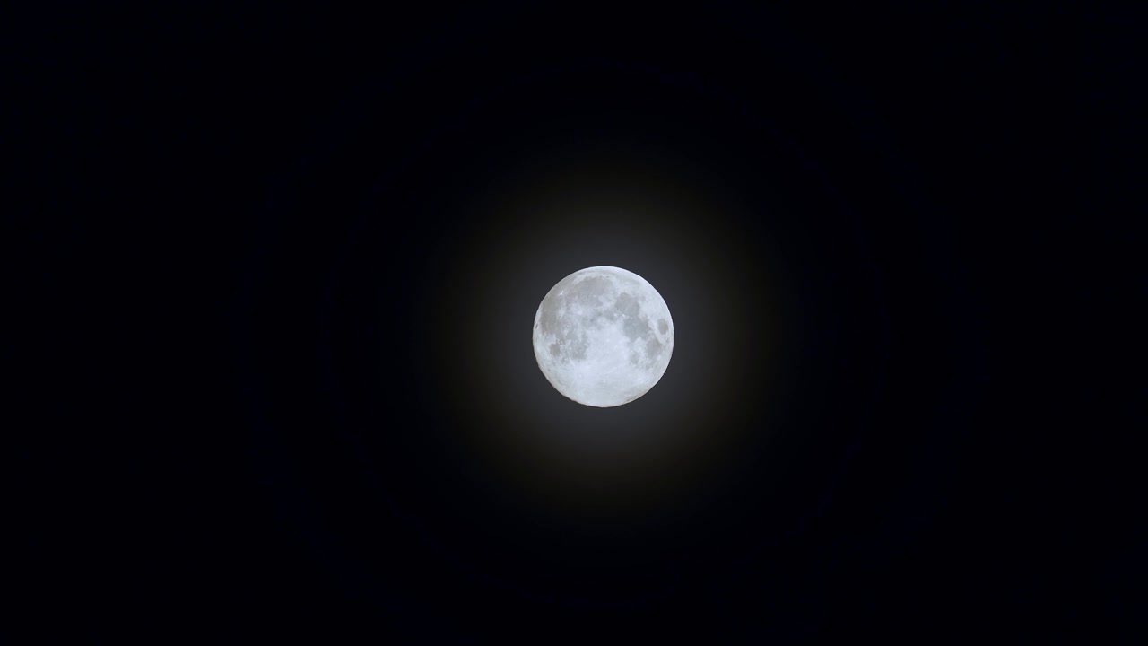 Uma lua cheia contra um céu noturno escuro. Imagem de telefoto de uma lua em fase cheia.