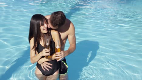 Couple-in-swimming-pool-hold-frothy-drinks