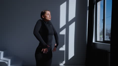 woman in black workout clothes standing in a studio