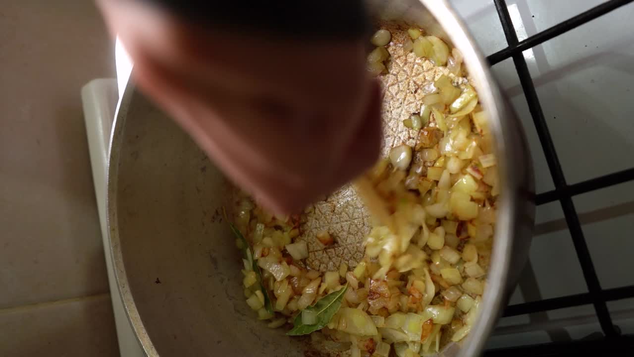 tiro vertical - cebolla salteada en una sartén con aceite de cocina