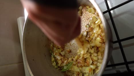 tiro vertical - cebolla salteada en una sartén con aceite de cocina