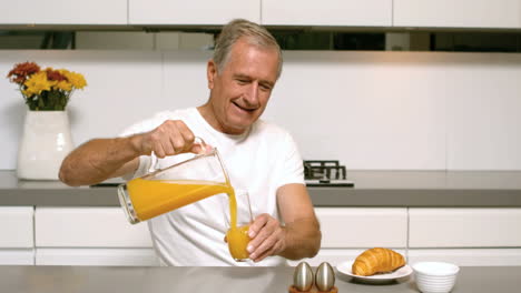 Retired-man-pouring-orange-juice-for-breakfast