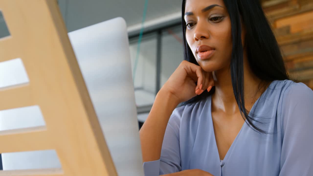 Female executive using laptop in the office 4k
