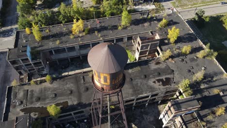 old rusty water tower of packard plant in detroit, aerial drone view