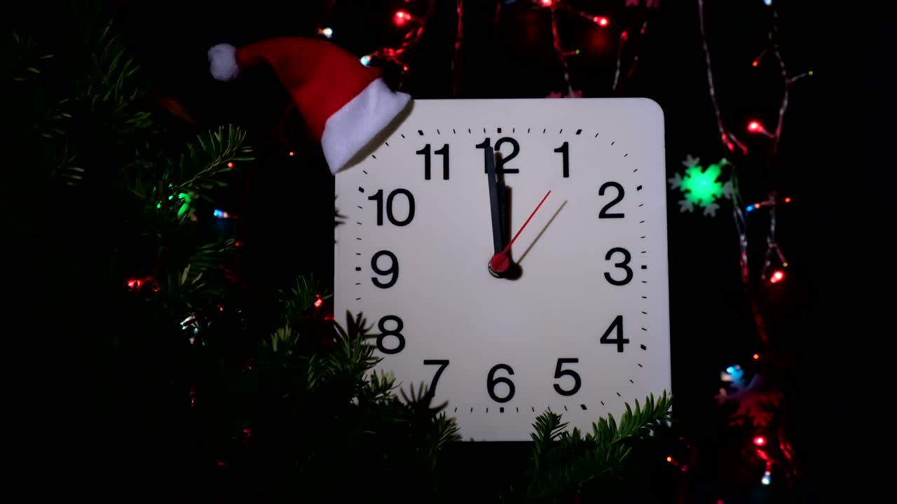 reloj en ramas de abeto de año nuevo en fondo negro. la manilla de segundos se mueve en círculo de reloj mecánico y muestra las doce en punto a medianoche y víspera de navidad. concepto de vacaciones, lapso de tiempo, primer plano, primer plano