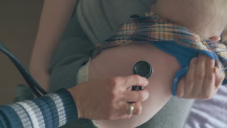 mommy helps pediatrician listen to little baby lungs