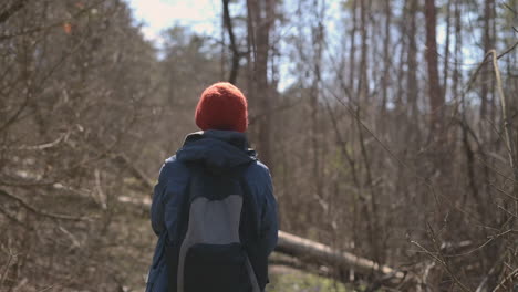 Mujer-Joven-Con-El-Pelo-Corto-Da-Un-Paseo-Por-El-Bosque-Sosteniendo-Un-Perro-Pequeño-3