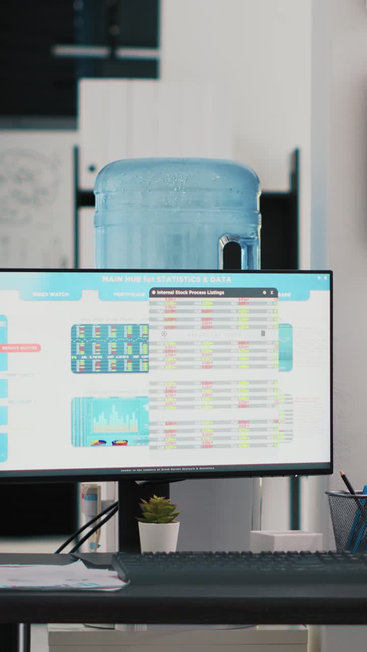 Vertical video Company workspace with nobody in and business figures on computer monitors