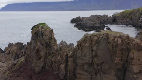 calm water on a rocky sea stack by the coast of iceland during daytime