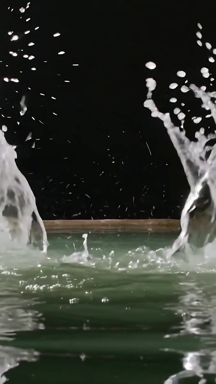 Video verticale: Goccioline che colpiscono l'acqua creando getti e spruzzi per uno studio in studio, con bordo e sfondo.