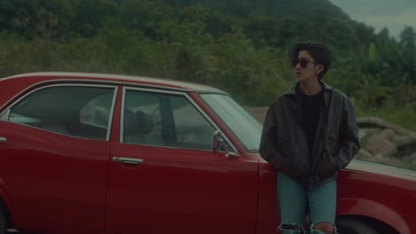 young person by a classic red car
