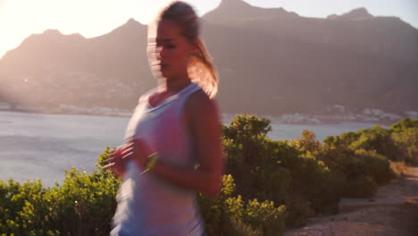 woman running towards camera on a coastal road