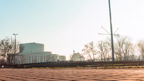 a sun-rise time-lapse of traffic on a city road ahead of the opera nova in bydgoszcz poland.
