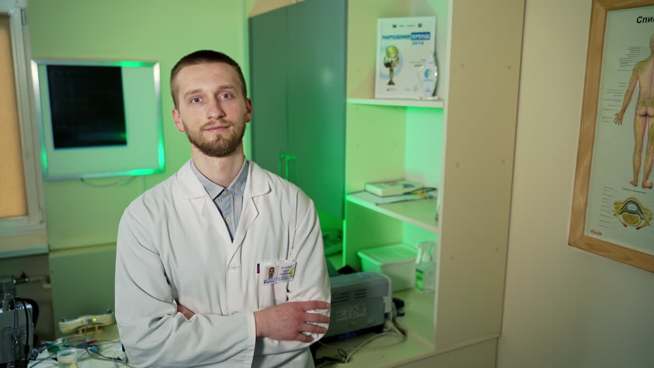Médico posando para a câmera. Jovem médico alegre posando e sorrindo para a câmera.