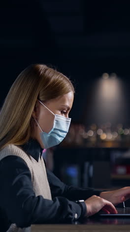 businesswoman in mask working in modern workplace. quarantine business work. vertical video