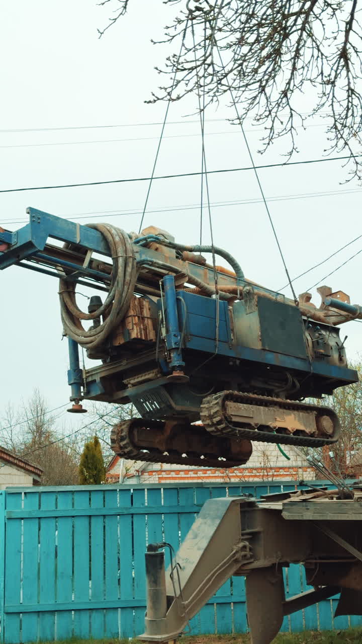 Water drilling equipment. Digging a hole in ground with rig machine. Vertical video.
