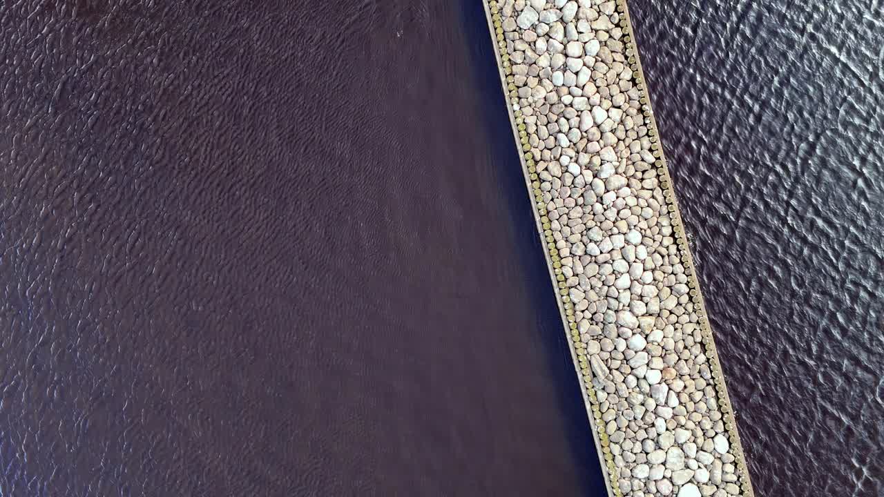 воздушный дрон летает над каменной док-дорогой, разделяющей океанские воды сверху вниз, один вид, без людей, мотивационный клип