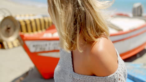 Mujer-Sonriente-Vistiendo-Un-Suéter-Gris-En-La-Playa