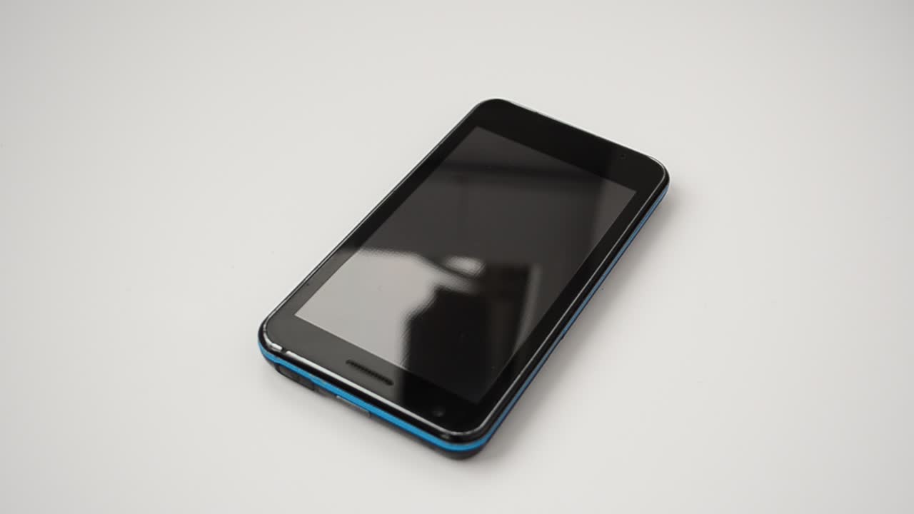 Sort moderne smartphone. Sort moderne smartphone med blank skærm ligger på overfladen, isoleret på hvid baggrund.
