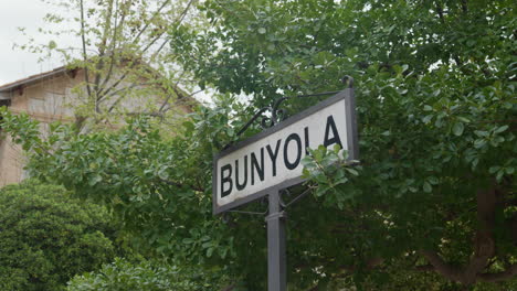 green trees frame the bunyola town sign in mallorca