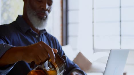 Senior-man-pouring-water-from-french-press-into-a-cup-4k